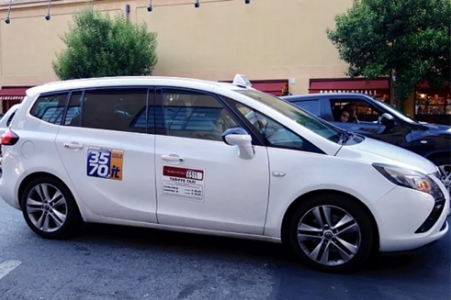 Bílé římské taxi s označením TAXI a licenčními údaji